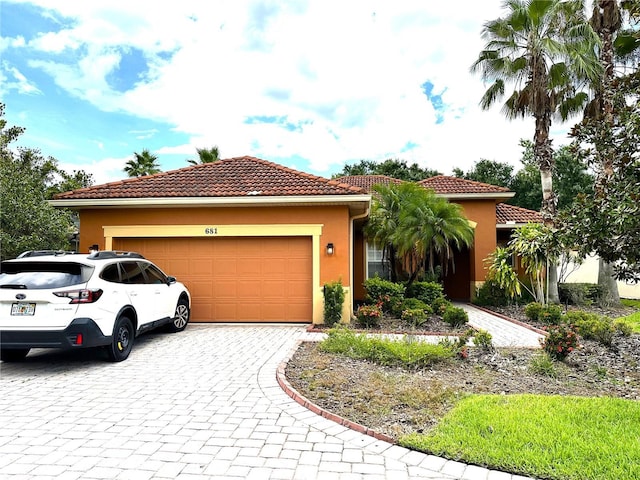 681 Coronado Dr, Kissimmee, FL 34759 - mediterranean / spanish-style home featuring a tile roof, decorative driveway, a garage, and stucco siding