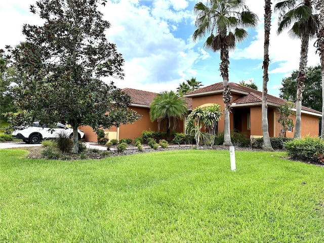 681 Coronado Dr, Kissimmee, FL 34759 - view of front of home featuring stucco siding, a front lawn, and a tiled roof