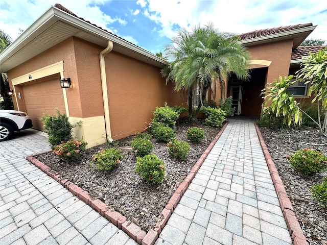 681 Coronado Dr, Kissimmee, FL 34759 - view of front of home featuring driveway, stucco siding, a garage, and a tiled roof