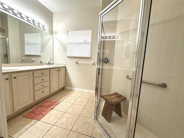681 Coronado Dr, Kissimmee, FL 34759 - full bath with a shower stall, baseboards, double vanity, tile patterned floors, and a sink