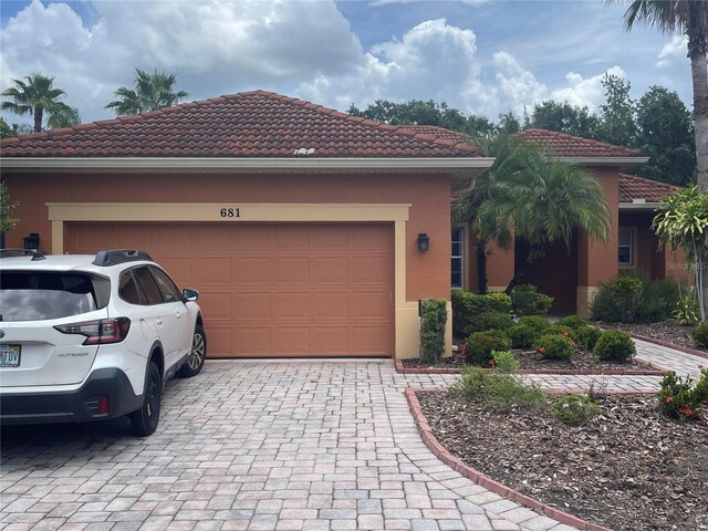 681 Coronado Dr, Kissimmee, FL 34759 - view of front of property featuring a tiled roof, stucco siding, decorative driveway, and a garage