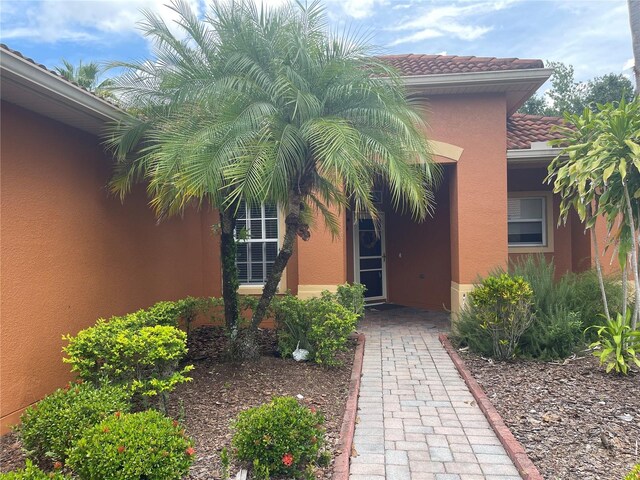 681 Coronado Dr, Kissimmee, FL 34759 - entrance to property with stucco siding and a tiled roof
