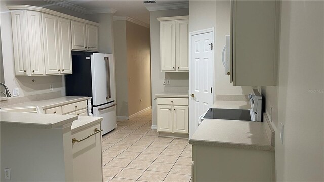681 Coronado Dr, Kissimmee, FL 34759 - kitchen with white appliances, crown molding, light tile patterned flooring, a peninsula, and light countertops