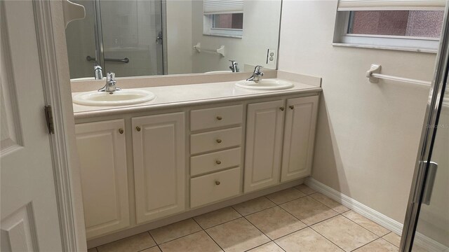 681 Coronado Dr, Kissimmee, FL 34759 - bathroom featuring double vanity, tile patterned floors, and a shower stall