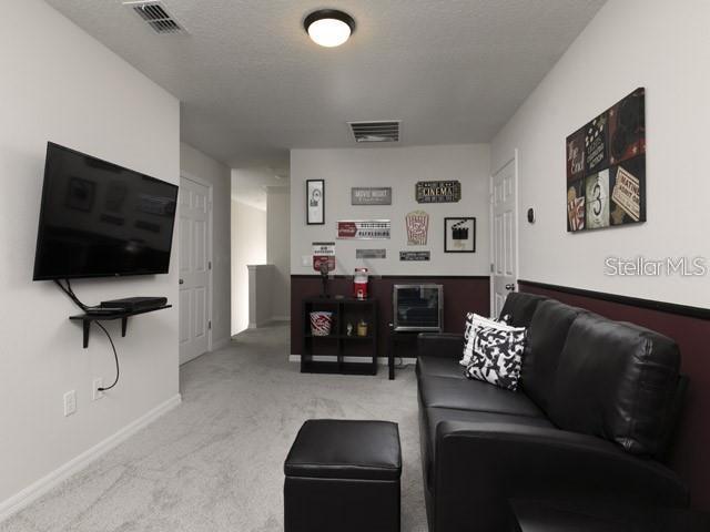 carpeted living room with a textured ceiling