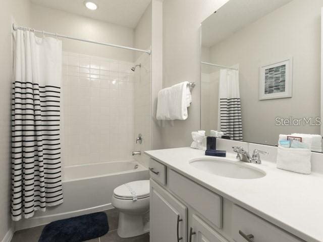 full bathroom with shower / bath combo, vanity, tile patterned floors, and toilet