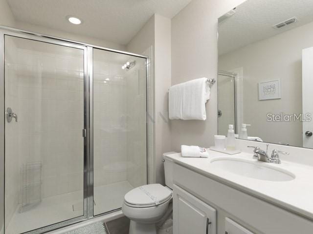 bathroom with vanity, toilet, and a shower with shower door