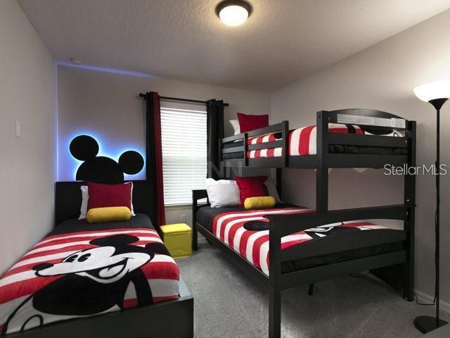 bedroom with carpet floors and a textured ceiling