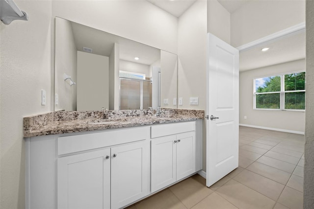 bathroom featuring vanity, tile patterned floors, and walk in shower