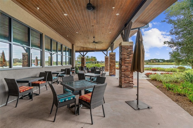 view of patio with a water view and ceiling fan