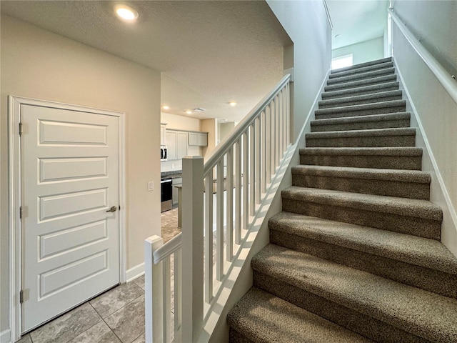 stairway featuring light tile patterned floors