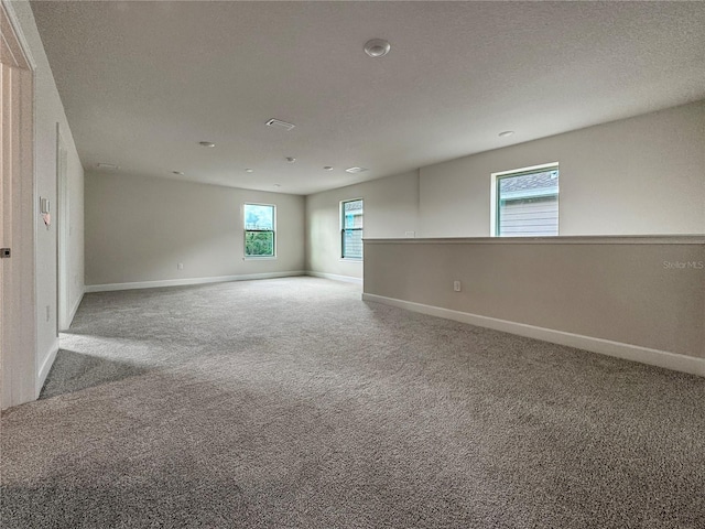 carpeted empty room with a textured ceiling