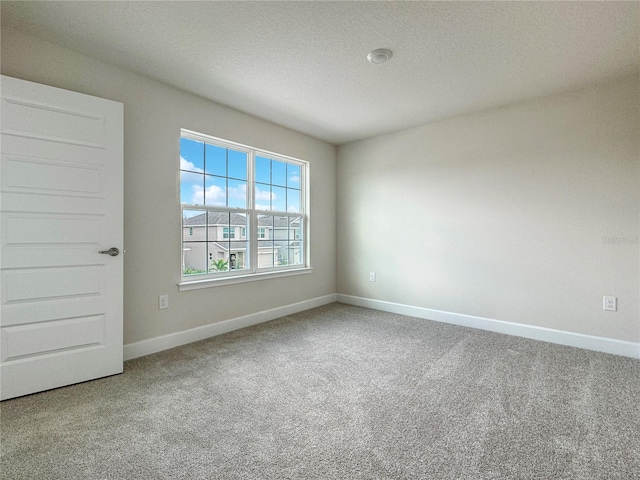 carpeted empty room with a textured ceiling