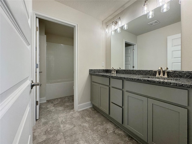 bathroom with vanity, a textured ceiling, and shower / bath combination