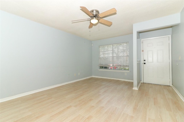 spare room with a ceiling fan, baseboards, and light wood finished floors