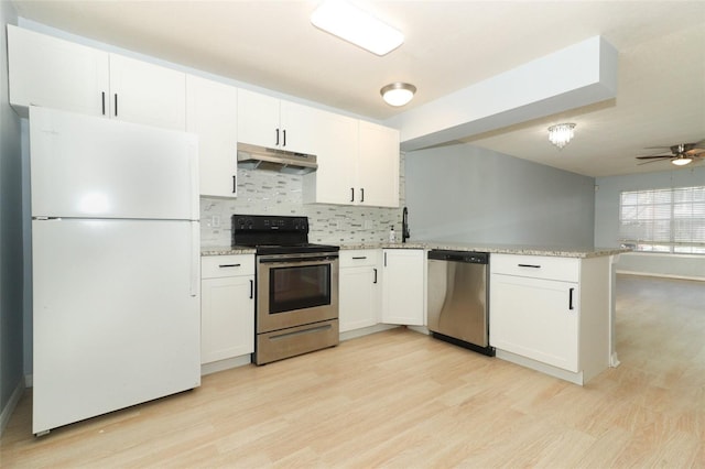 kitchen featuring under cabinet range hood, a peninsula, light wood-style floors, white cabinets, and appliances with stainless steel finishes