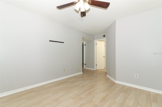 empty room with baseboards, ceiling fan, visible vents, and light wood-style floors