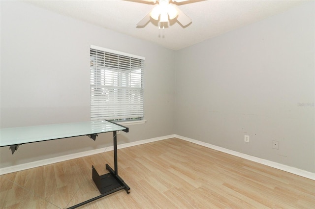 office area featuring baseboards, ceiling fan, and light wood-style floors