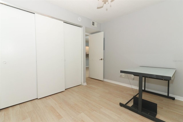 home office with a ceiling fan, baseboards, visible vents, and wood finished floors