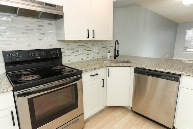 kitchen featuring under cabinet range hood, stainless steel appliances, a sink, white cabinetry, and light wood finished floors