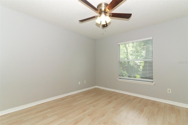 unfurnished room with baseboards, ceiling fan, a textured ceiling, and light wood finished floors