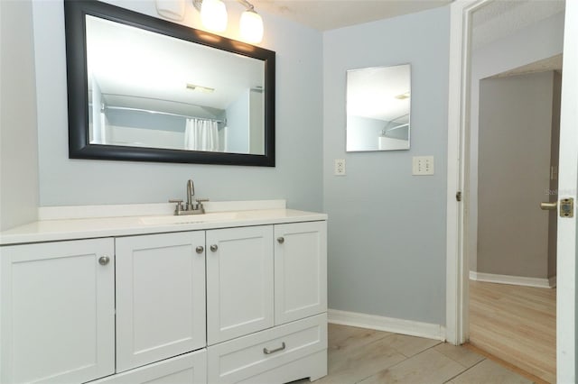 full bathroom featuring visible vents, vanity, baseboards, and wood finished floors