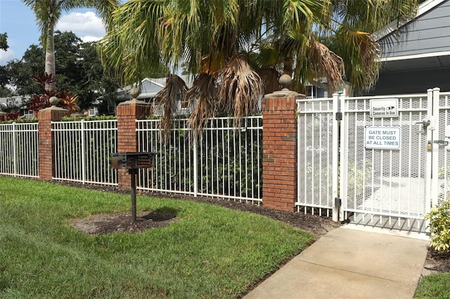 view of gate with a yard and fence