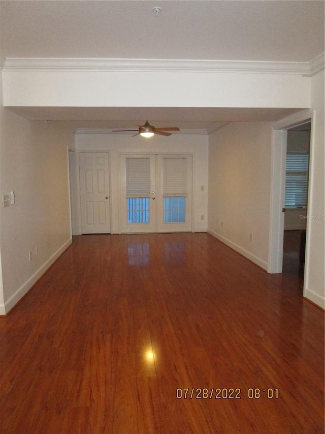 unfurnished living room with ceiling fan, dark hardwood / wood-style flooring, ornamental molding, and french doors