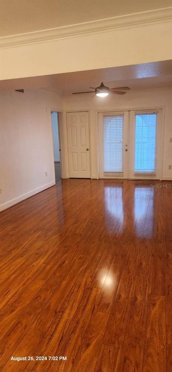 spare room featuring french doors, crown molding, and dark wood-type flooring