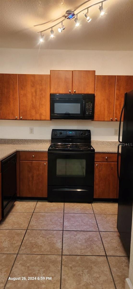 kitchen with light tile patterned floors and black appliances