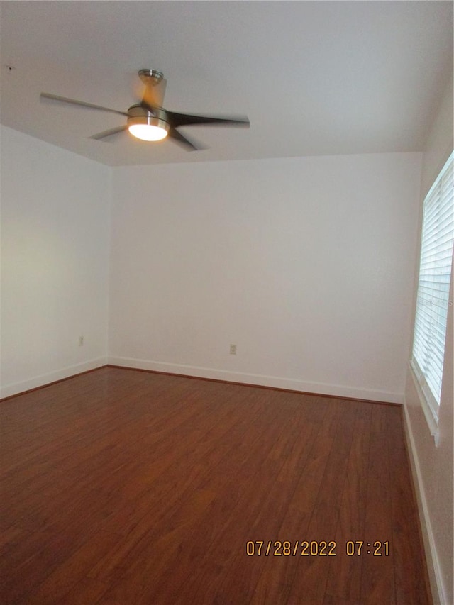 empty room with ceiling fan and dark wood-type flooring