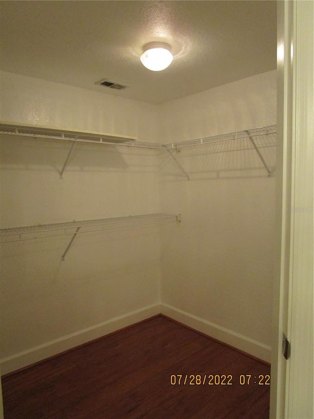 spacious closet featuring dark hardwood / wood-style floors