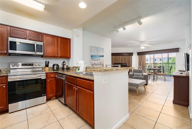 kitchen featuring kitchen peninsula, appliances with stainless steel finishes, ceiling fan, and sink