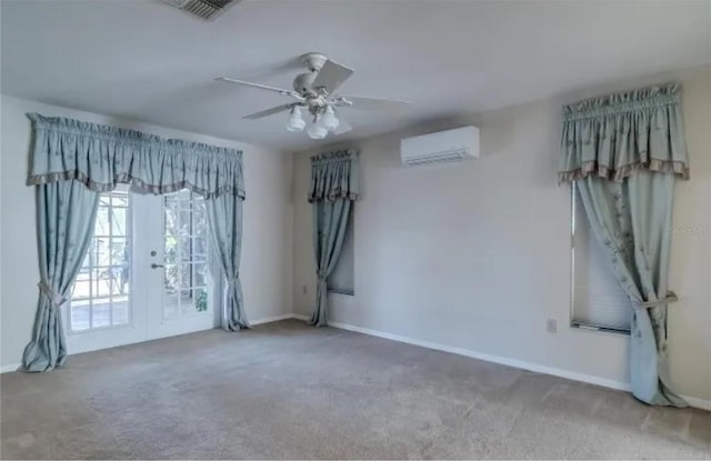 carpeted empty room featuring ceiling fan, french doors, and a wall mounted AC