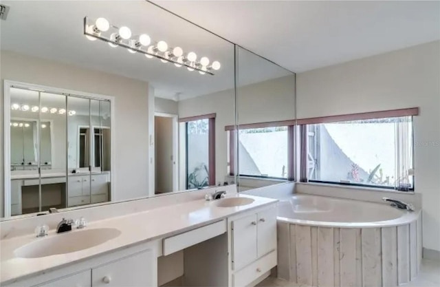 bathroom with vanity and a tub to relax in