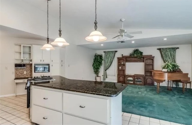 kitchen with tasteful backsplash, white cabinetry, hanging light fixtures, a center island, and gas range