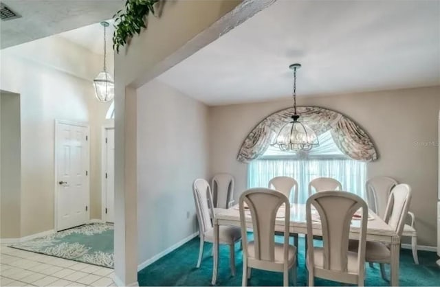 tiled dining room with a chandelier