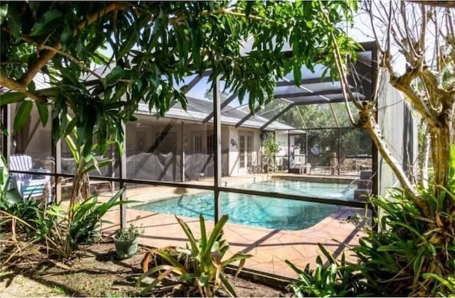 view of swimming pool with a patio area and glass enclosure