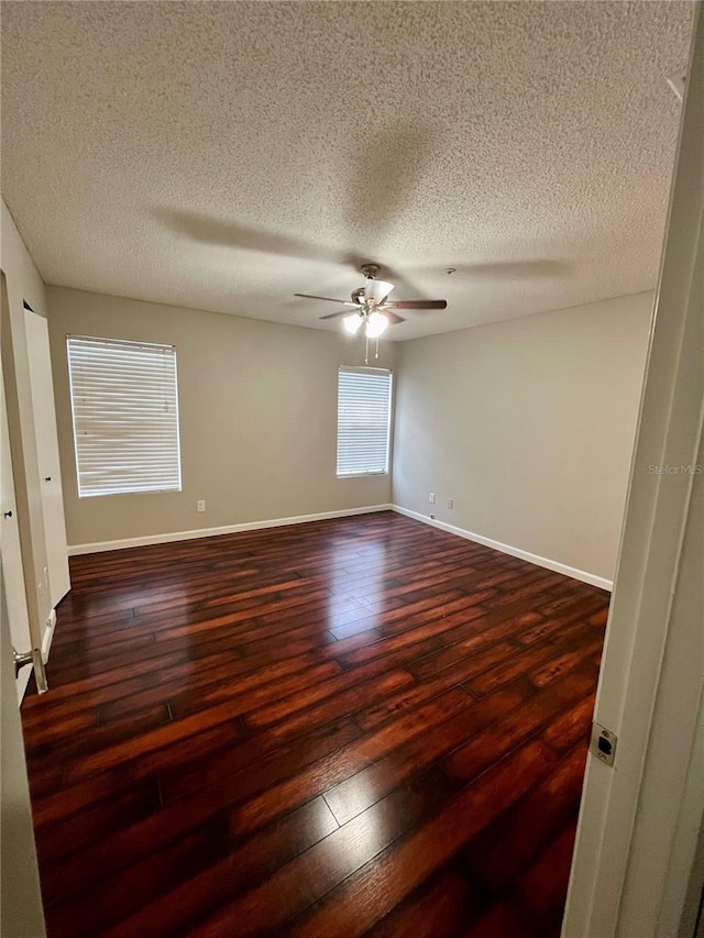 spare room featuring a textured ceiling, ceiling fan, and dark hardwood / wood-style floors