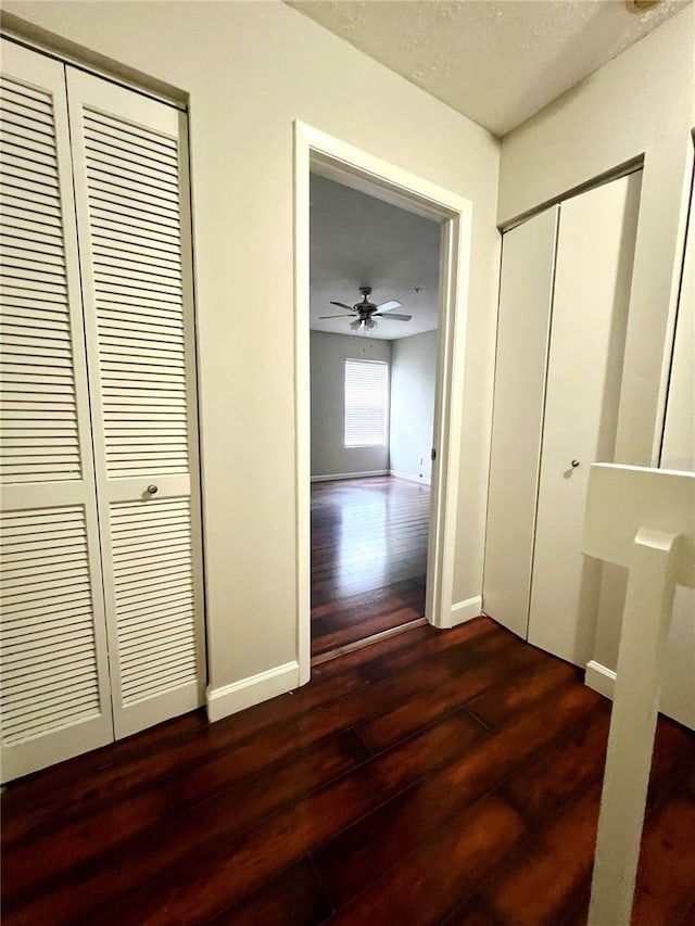 corridor featuring a textured ceiling and dark hardwood / wood-style floors