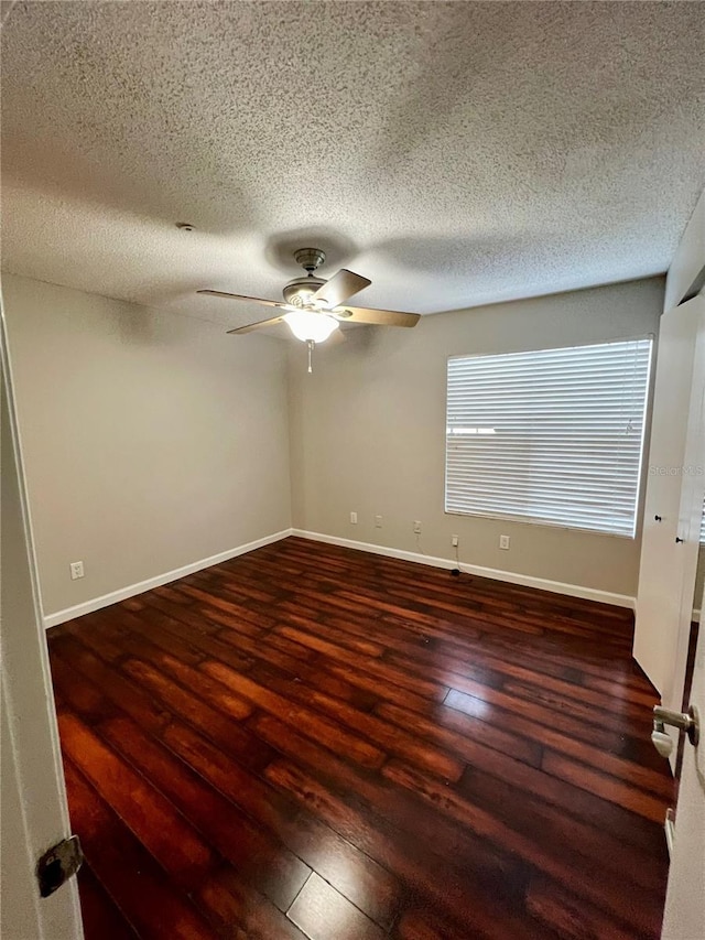 empty room with a textured ceiling, ceiling fan, and dark hardwood / wood-style flooring