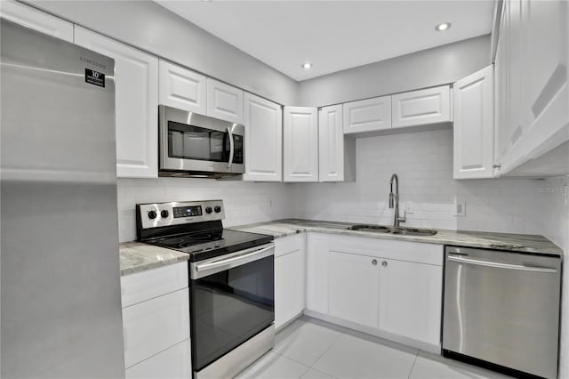 kitchen with light tile patterned floors, white cabinetry, appliances with stainless steel finishes, and sink