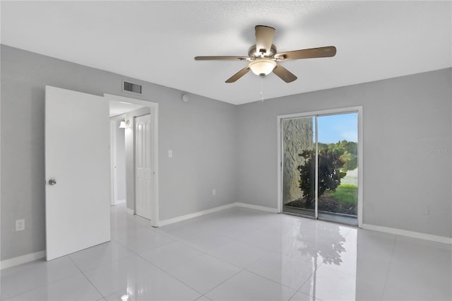 tiled empty room with ceiling fan