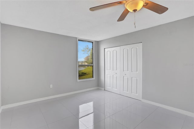 unfurnished bedroom with a closet, tile patterned floors, and ceiling fan