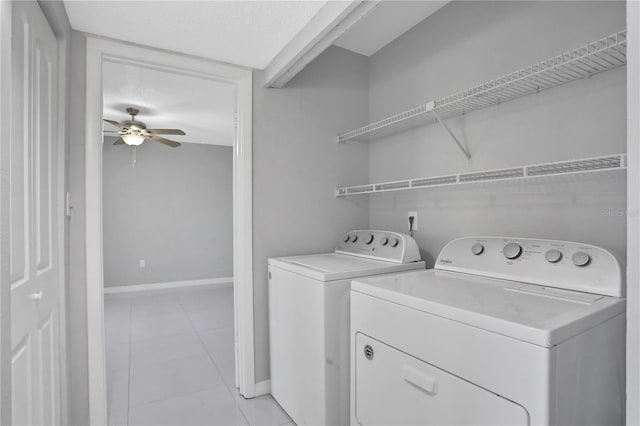 laundry area with light tile patterned floors, washing machine and dryer, and ceiling fan