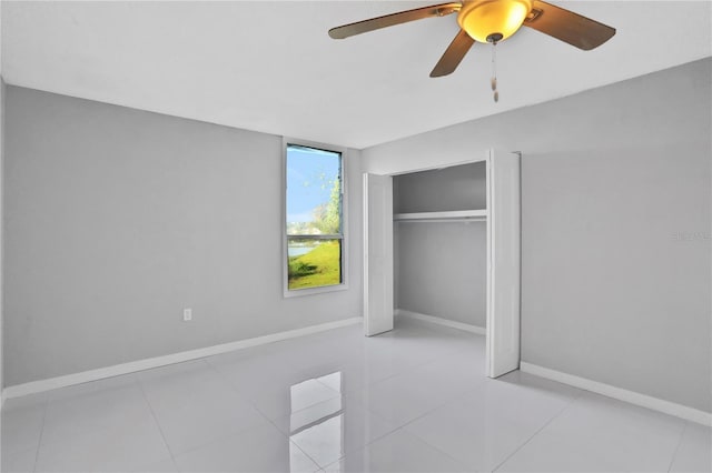 tiled bedroom with ceiling fan and a closet