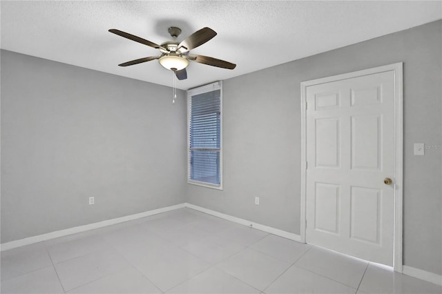 tiled empty room featuring a textured ceiling and ceiling fan