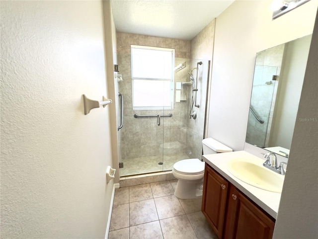 bathroom featuring toilet, tile patterned floors, walk in shower, and vanity