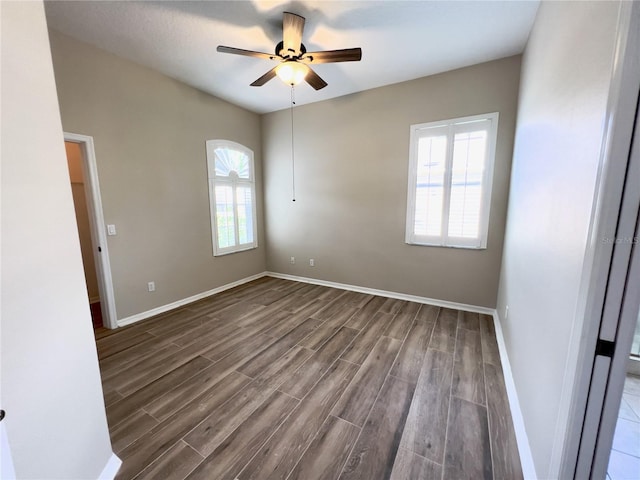 empty room with ceiling fan and dark hardwood / wood-style flooring