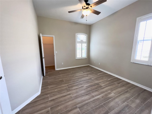 spare room featuring ceiling fan, a healthy amount of sunlight, and dark hardwood / wood-style floors